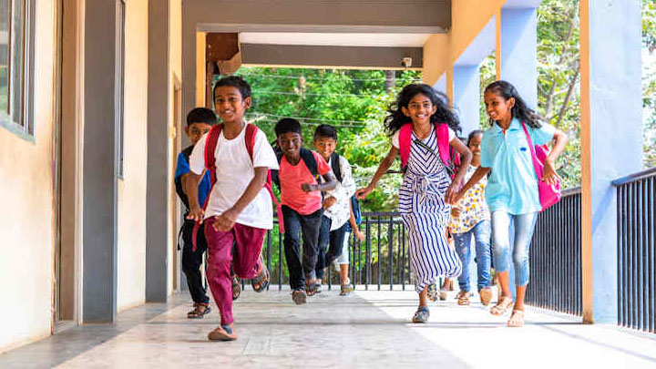South Asian children running at school.