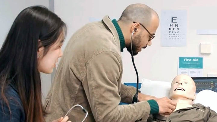 Pharmacy students learning clinical skills on a Sim man.