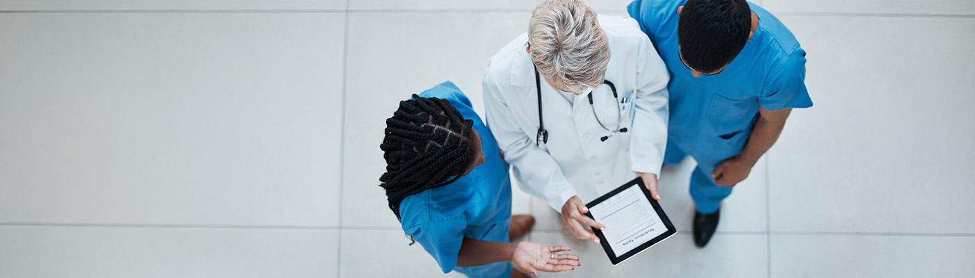 Three healthcare workers having a consultation around a tablet pc.