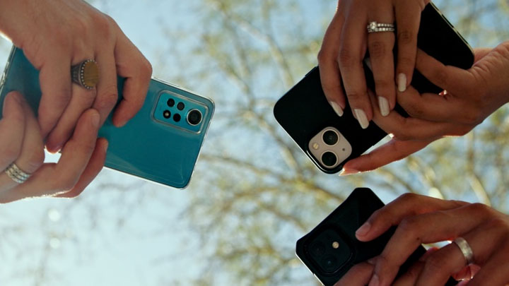 Three people holding smartphones.