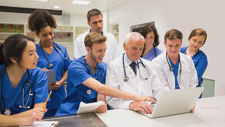 A small group of medical students gathered around a consultant.