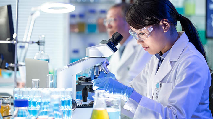 A researcher changing a microscope slide.