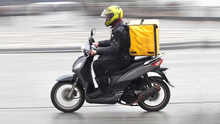A delivery worker on a motorbike.