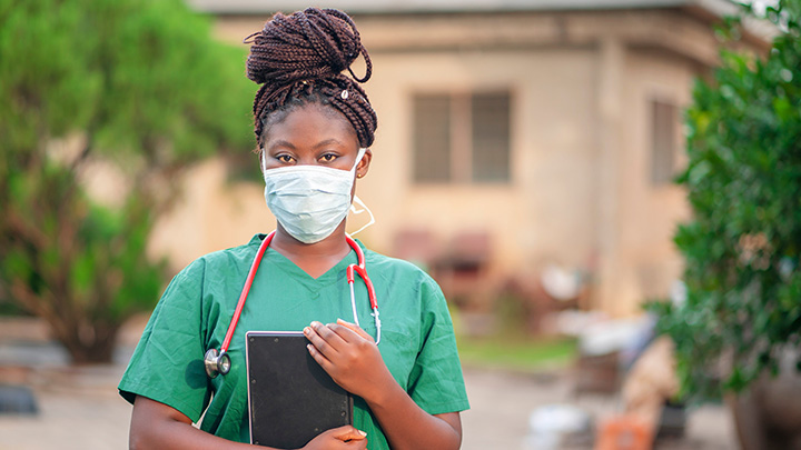 A nurse wearing a facemask outside a clinic in Africa.