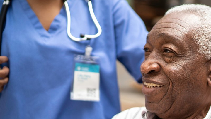 Man over 70 sitting and smiling after leaving hospital.