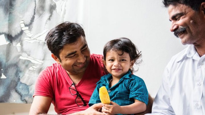 A Sri Lankan family playing together with a toddler.