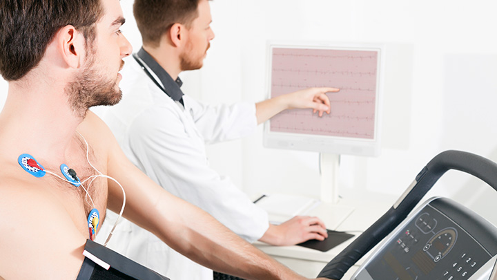 Doctor shows the patient the ECG recording of the electrical activity of the heart.