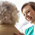 A health worker talking with an older woman.