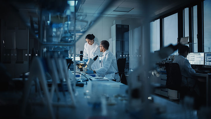 Two doctors working in a dark lab.