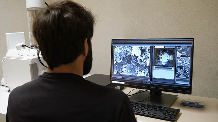 A technician studying SEM images on a screen.