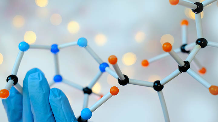 Close-up of hand holding a model of a molecular compound.