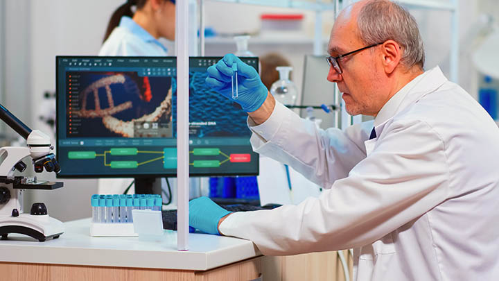 A researcher holding a test tube in a lab.