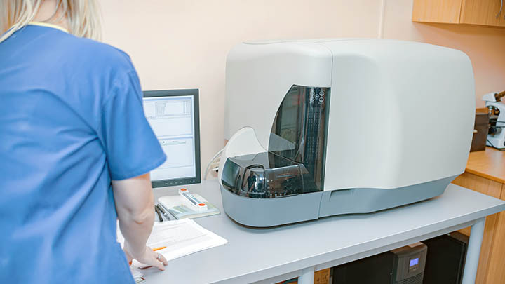 A researcher using a flow cytometer.
