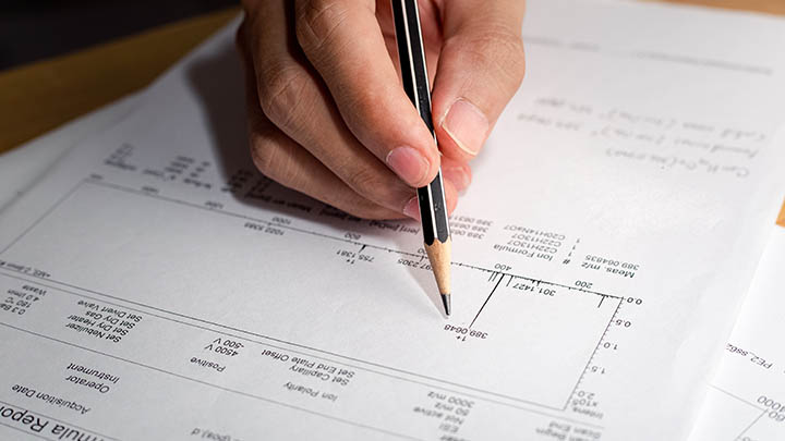 A researcher annotates a mass spectrometry report.