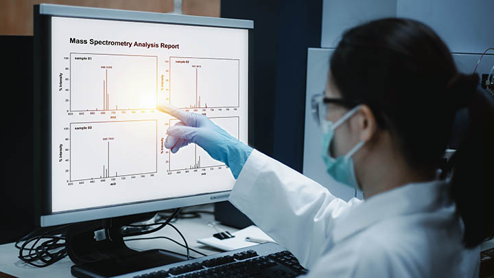 Researcher views a chromatogram of mass spectrometry analysis results of compounds.