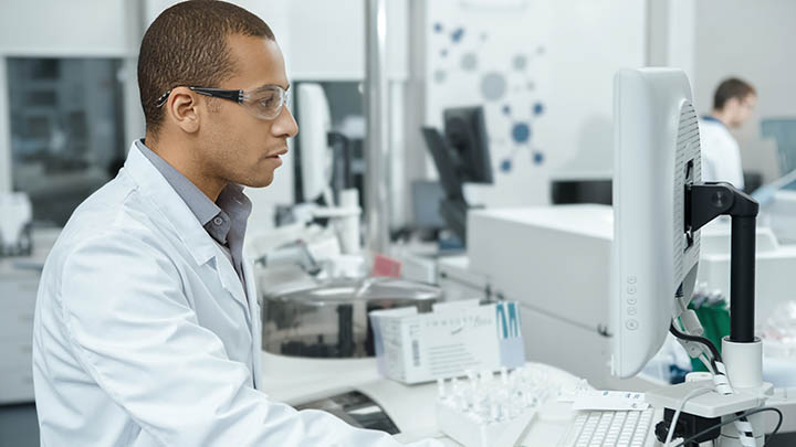 A researcher reviewing results on a pc in the lab.