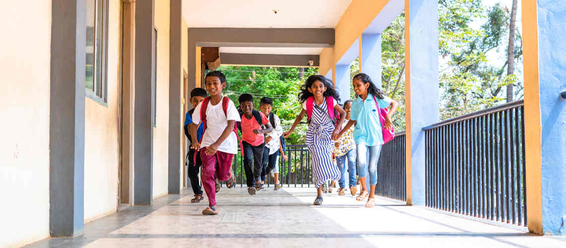 South Asian children running at school.