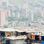 The roofs of houses against the backdrop of skyscrapers in a South American city.