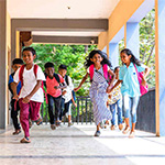 South Asian children running at school.