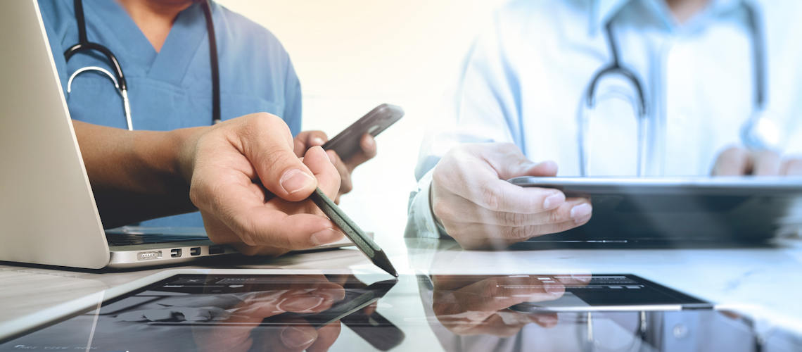 Two healthcare professionals looking at health data on a screen.