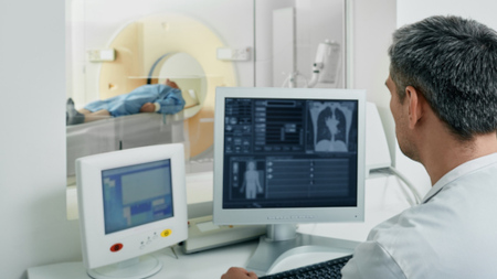 A medical professional observing a CT scan of a patient.