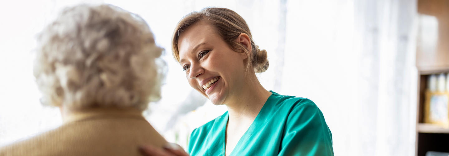 A health worker talking with an older woman.