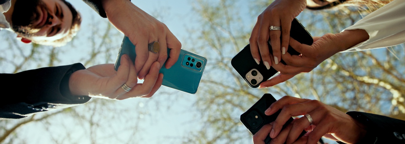 Three people holding smartphones.