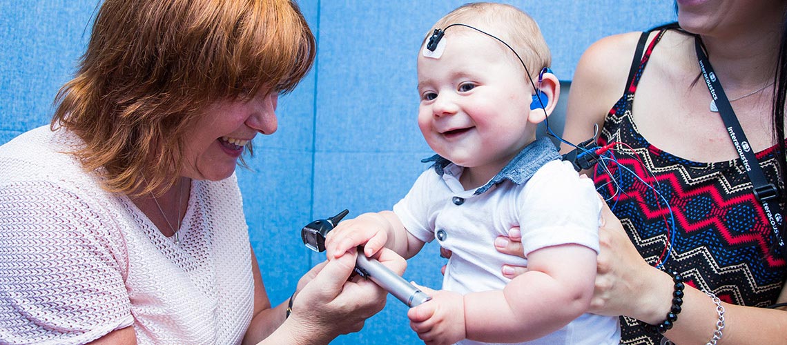 Audiologist with mother and child