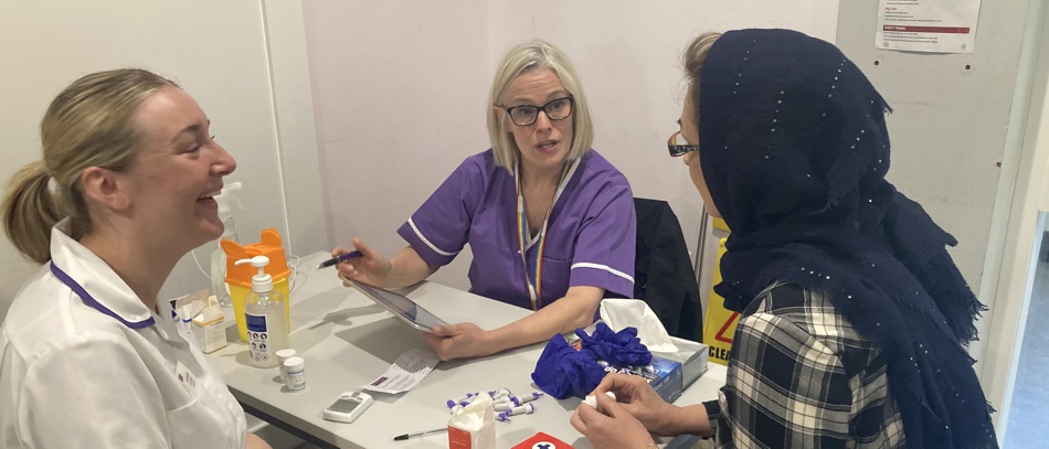 A Manchester student talking to two women.