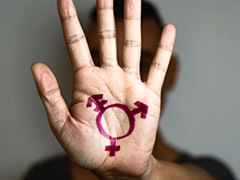 closeup of a transgender symbol painted on the palm of the hand