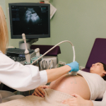 A doctor listening to the heartbeat of a male patient.