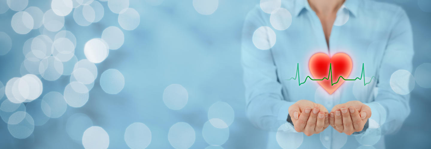 A woman holding a graphic of a heart in her hands.