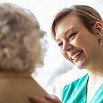 A health worker talking with an older woman.