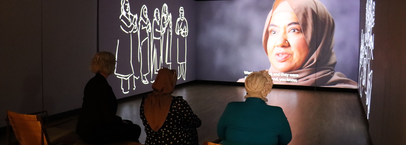 Suzanne Johnson, Binish Khatoon and Ncazelo Ncube watching a film featuring Asian women at the Manchester Museum.