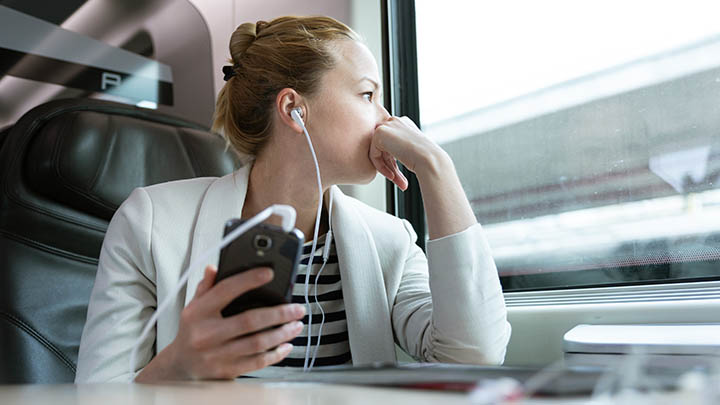 A person listening to a podcast on a train.