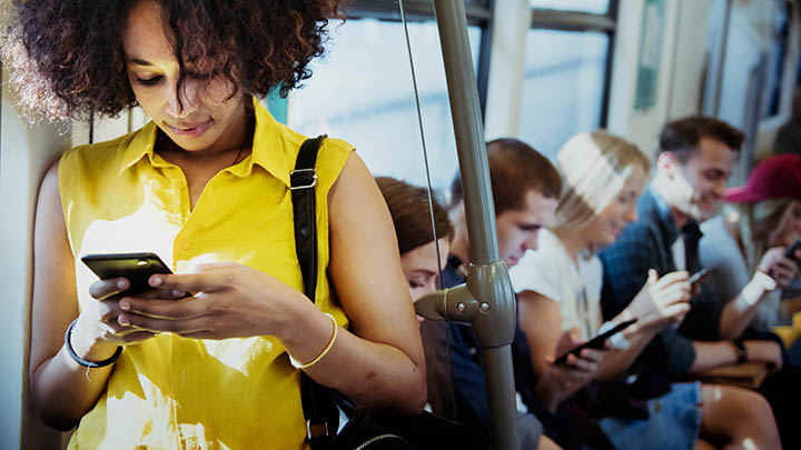 People using mobile phones on a train.