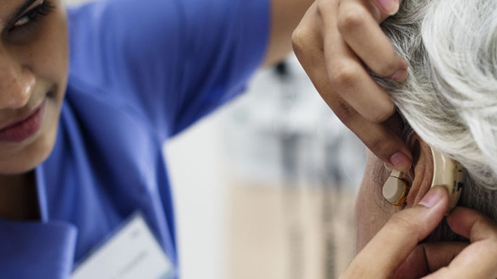 A patient having her hearing aid fitted.