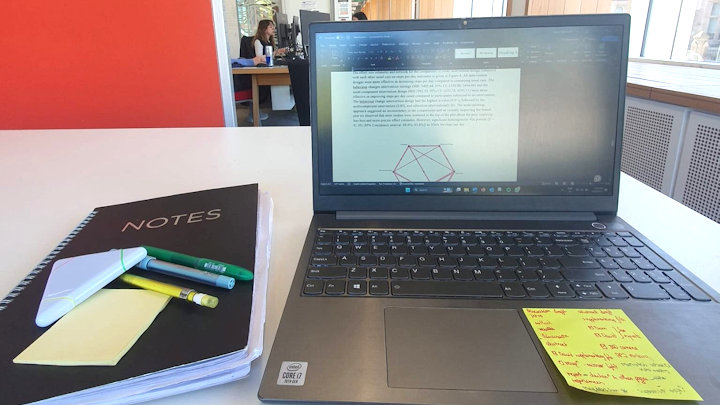 A photo of Harsini's laptop and notebook.