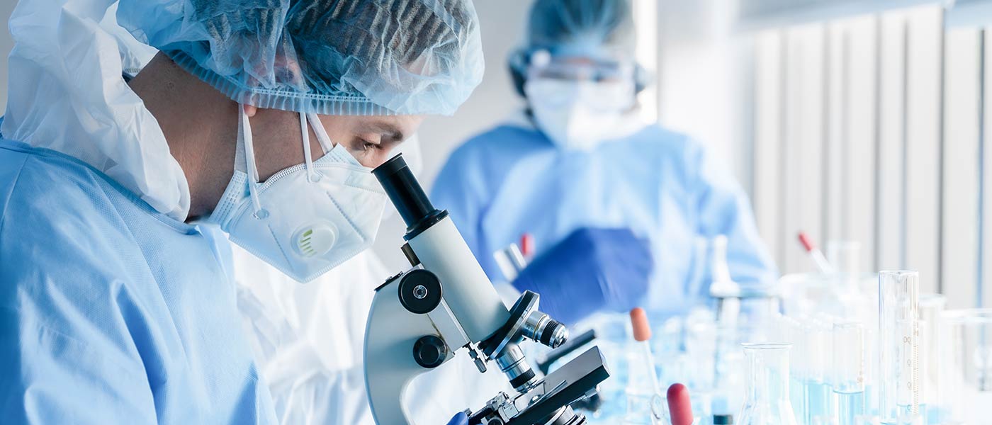 Student looking down a microscope in a lab