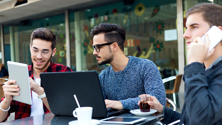 A team discussing a plan outside a coffee shop.