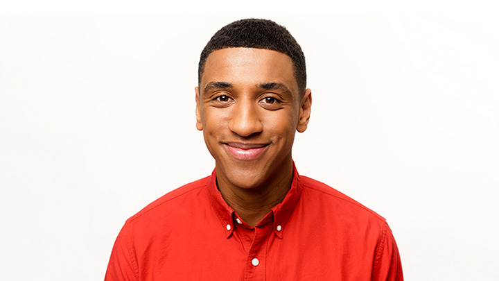 A smiling student wearing a red shirt.