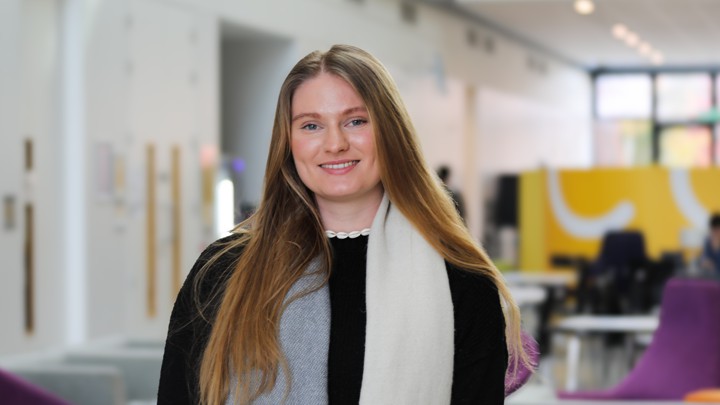 Medical student Ellen smiling towards the camera in a clinical setting.