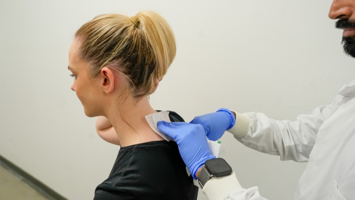 A doctor taking a neck swab from a patient.