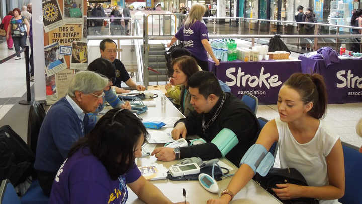 University students checking blood pressure as part of a service learning project.