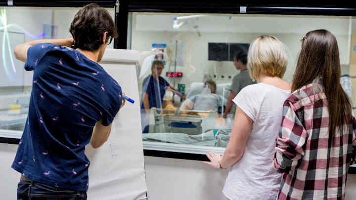 Medical student undergoing evaluation in hospital training suite.