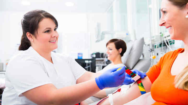 A nurse taking blood from a donor.