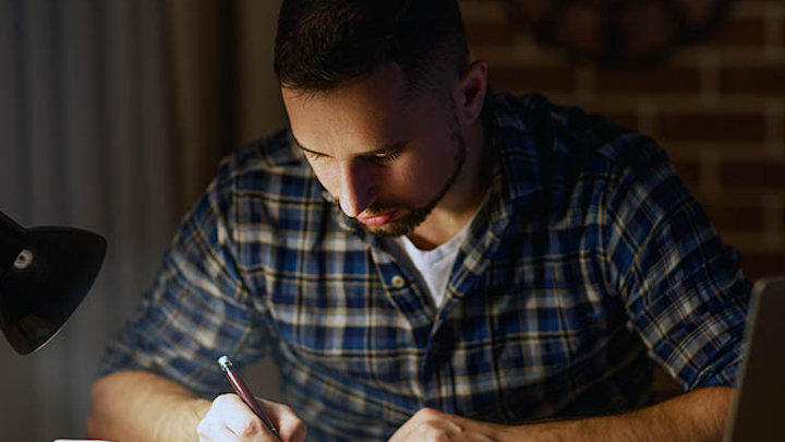 Student studying at home in the evening.