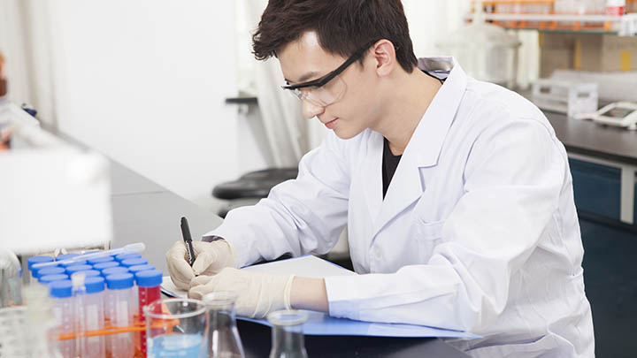 A student making notes in a lab book.