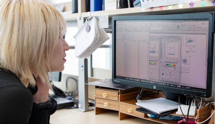 A postgraduate research sat at a desk looking at a computer screen