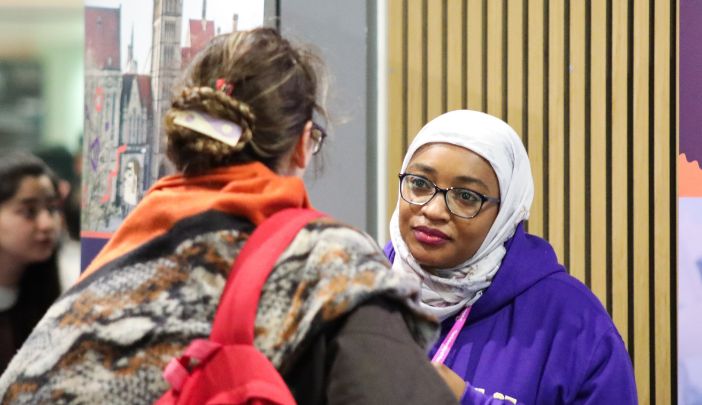 A postgraduate researcher listens intently to an open day attendee